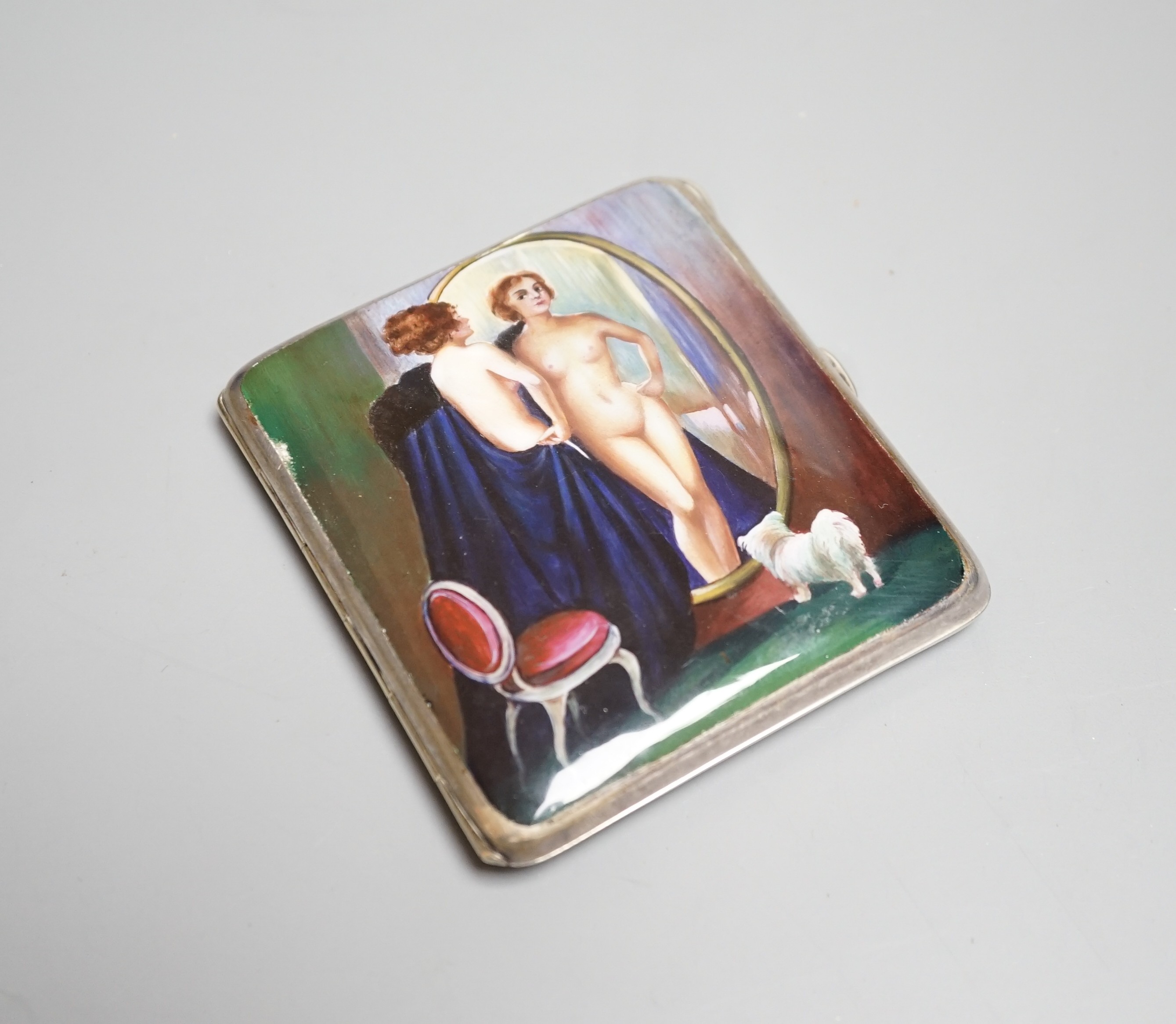 A Continental silver plated cigarette case, early 20th century, lid with erotic enamel scene of naked lady standing in front of a cheval mirror, gilt interior stamped ALPARP, height 8.5cms.